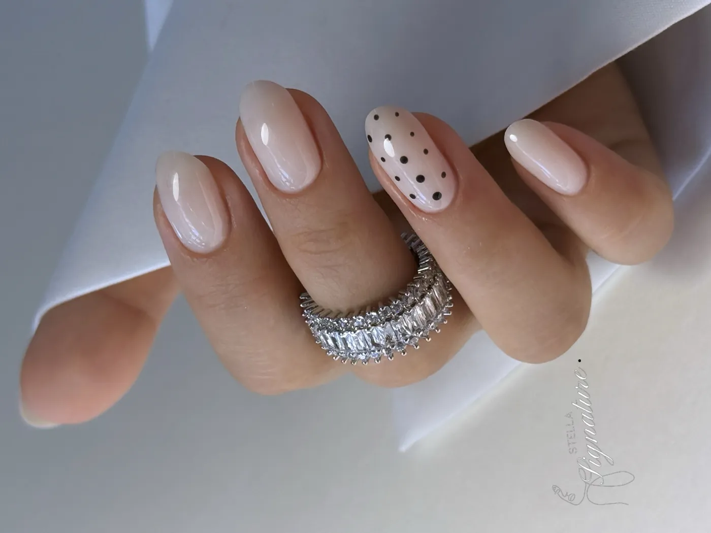 Nude laiteux, un ongle à pois noirs